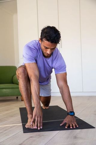 Young Man Practicing Lunges for Fitness at Home in Relaxed Environment