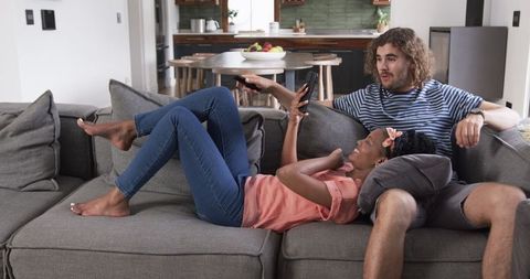 Interracial Couple Relaxing on Sofa Sharing Quality Time