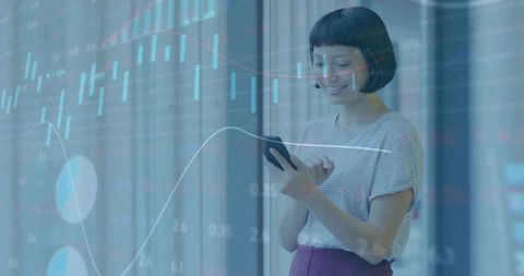 Young woman analyzing stock charts on smartphone with glass data overlay in office