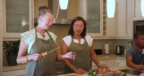 Senior friends enjoying culinary activity together in kitchen