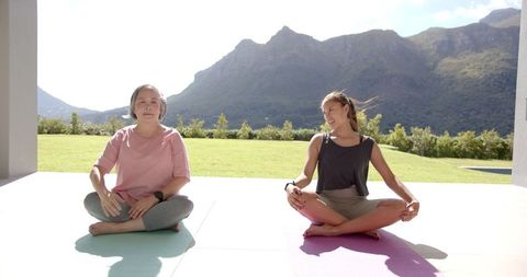 Two Women Practicing Yoga in Tranquil Mountain Environment