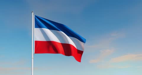 Tricolor flag unfurls gracefully, offering a symbol of national pride and unity against vibrant sunset sky. Perfect for visuals symbolizing patriotism, freedom, or ceremonial events. Can be used for educational, cultural, or promotional materials emphasizing unity and pride.