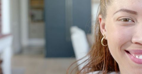 Smiling young woman showing right half-face wearing hoop earring with copy space