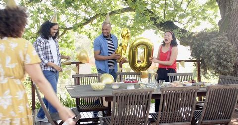 Diverse Friends Preparing for Outdoor Birthday Celebration