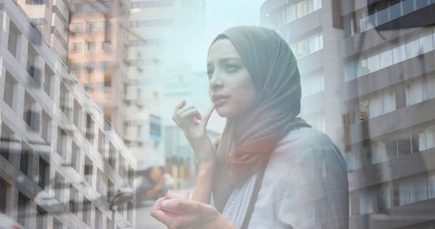 Asian Woman in Hijab Blurs with Modern Cityscape