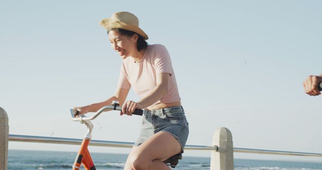 Smiling Young Woman Biking Outdoors by Ocean - Download Free Stock Images Pikwizard.com
