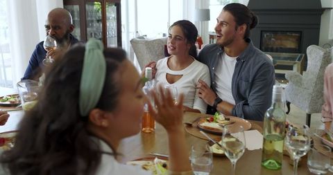 Family Enjoying Meal Together with Laughter and Wine