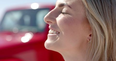 Young Woman Smiling in Sunlight during Road Trip Adventure