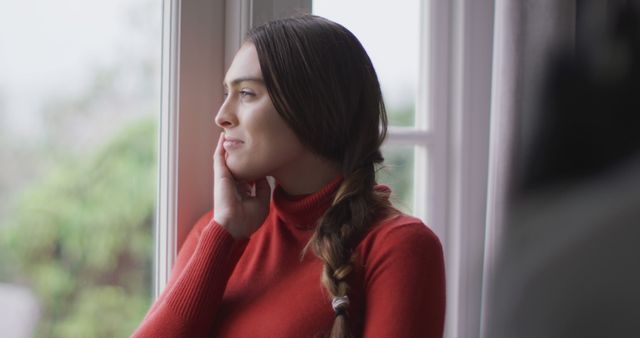 Young Woman Daydreaming by Window in Cozy Red Sweater - Download Free Stock Images Pikwizard.com