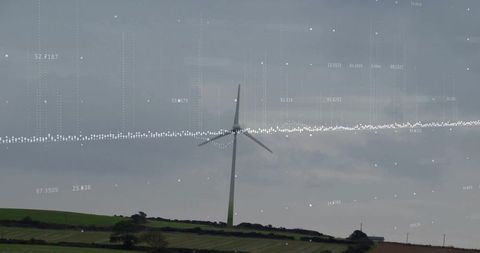 Wind turbine on pastoral ridge with digital waveform overlay monitoring wind energy data