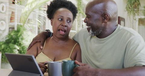 Senior Couple Sharing Relaxed Moments with Coffee and Technology