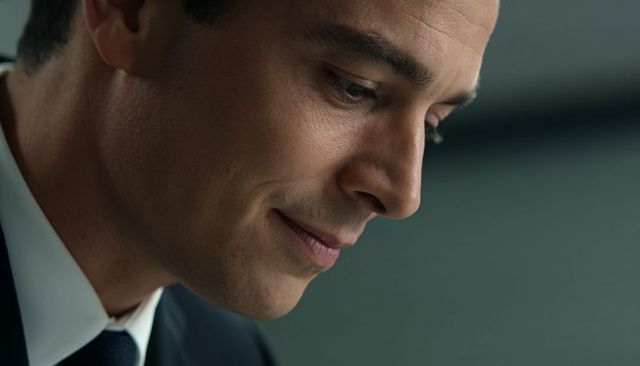Contemplative businessman headshot looking downward in suit and tie for corporate use