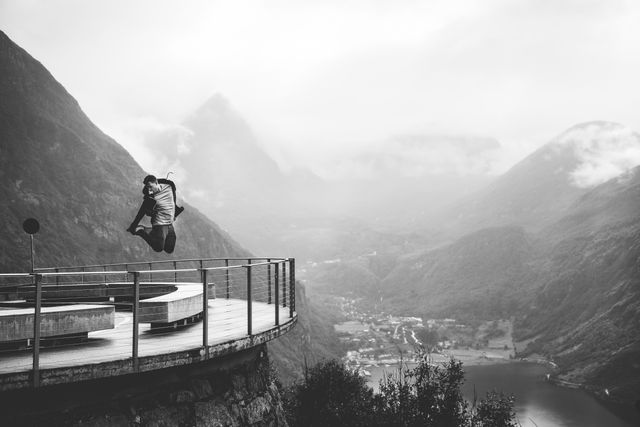 Man Jumping with Scenic Mountain View in Background in Black and White - Download Free Stock Images Pikwizard.com