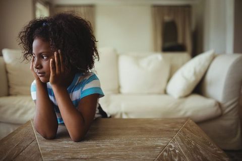 Contemplative Child Sitting by Sofa in Cozy Living Room - Download Free Stock Images Pikwizard.com