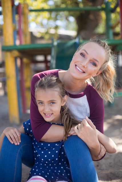 Portrait of happy mother and daughter enjoying at playground