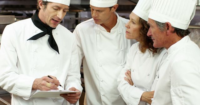 Head Chef Discussing Kitchen Operations with Team - Download Free Stock Images Pikwizard.com