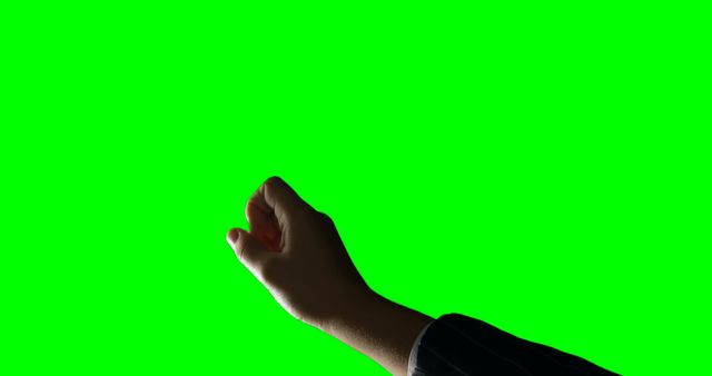Hand raised against a green screen background, perfect for adding custom backgrounds or special effects. Useful for presentations, video editing, communication symbols, and gesture studies.