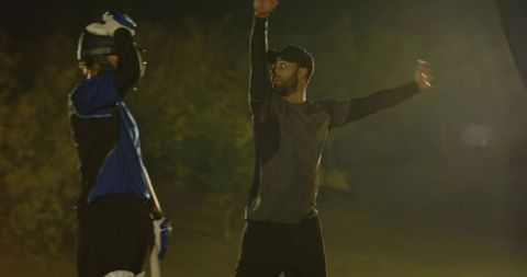 Bowler appealing for wicket under floodlights while batsman adjusting pads and bat