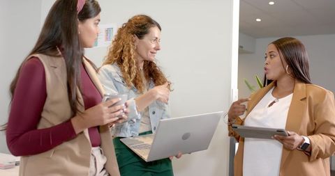 Diverse coworkers engaged in productive office conversation