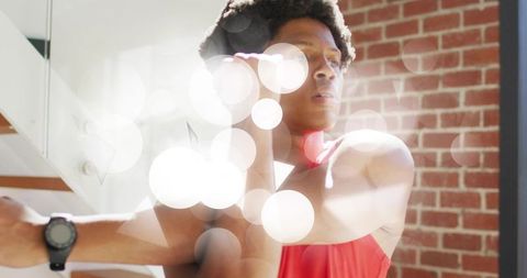 Athlete stretching in modern industrial fitness studio sunlit environment