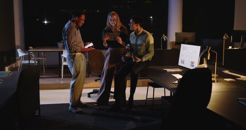 Diverse Team Analyzing Data on Tablet in Modern Office