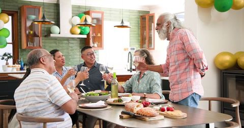 Diverse Senior Friends Enjoying Toast at Festive Dinner Party