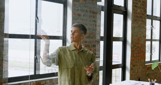 Woman Examining Windowpanes in Modern Office - Download Free Stock Images Pikwizard.com