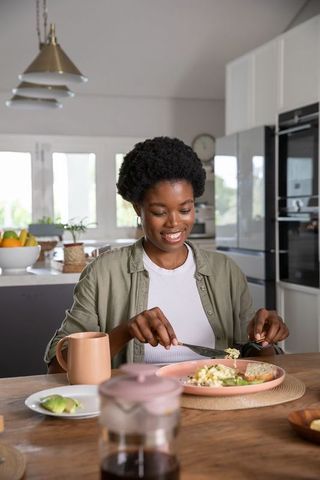 Smiling Woman Enjoying Healthy Breakfast in Modern Kitchen