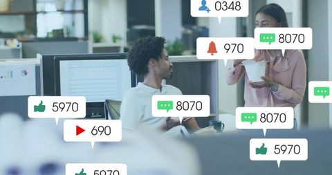 Coworkers discussing project with social media notification overlays in open office