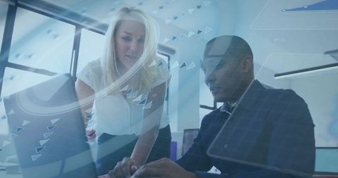 Diverse Team Collaborating Over Data on Laptop in Office Environment