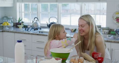 Caucasian Mother and Daughter Cooking and Playing in Bright Kitchen