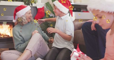 Family in Santa Hats Celebrating Christmas by Fireplace