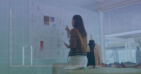 Fashion designer analyzing dress designs with digital interface