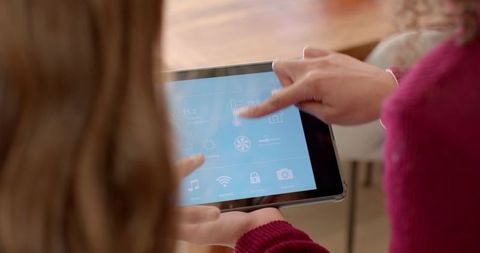 Women collaborating on smart home technology with tablet