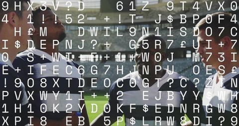 Rugby team huddling on stadium pitch discussing strategy before match with striped jerseys
