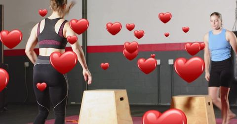 Women jumping on plyo boxes in gym with heart emoji overlay for fitness love