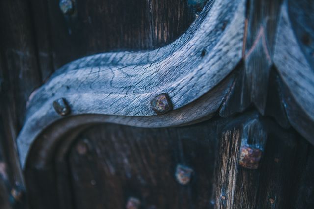 This is a close-up view of a weathered wooden door with metal accents, perfect for themes related to history, nostalgia, vintage designs, or rustic décor. Suitable for use in articles about historical architecture, background textures, or artistic projects seeking an antique look.