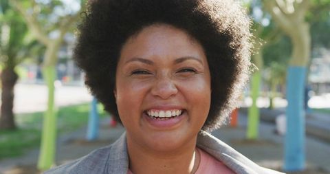 Cheerful Woman Enjoying Bright Day in Lush Park Setting