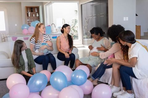 Diverse Women Celebrating Friendship with Baby and Balloons Indoors