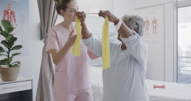 Elderly woman receiving help from nurse during physical therapy. Could be used for healthcare marketing, brochures on senior care, or articles related to physical rehabilitation and elderly support.