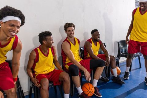 Diverse Male Basketball Team Exercising Team Spirit on Bench