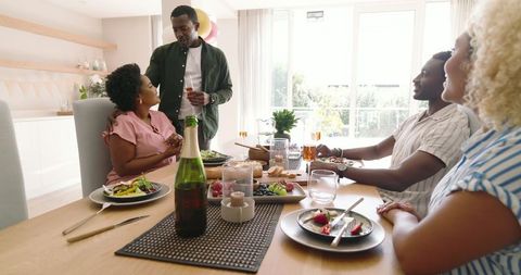 Friends gathering for a festive meal, enjoying company and laughter