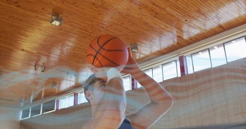 Male Athlete Focused on Accurate Basketball Shot in Gym