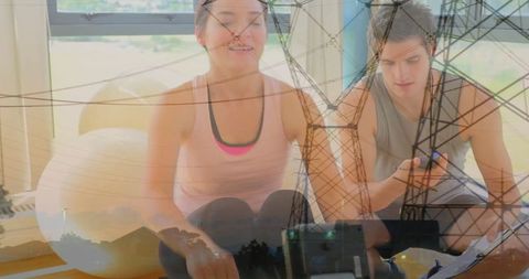 Partners training on rowing machines with sportswear indoors