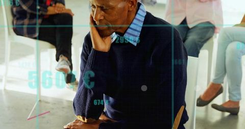 Contemplative man waiting in modern group session leaning forward on chair in waiting room