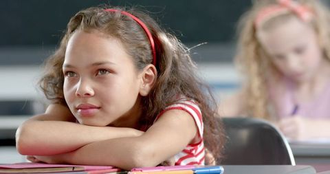 Young girl daydreaming in classroom setting