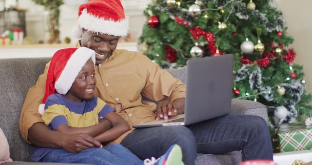 Happy african american father and son having image call. Spending quality time with family at christmas concept.