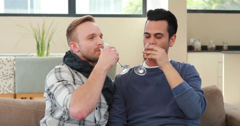 Friends Enjoying Relaxing Moment with Casual Drinks on Living Room Couch