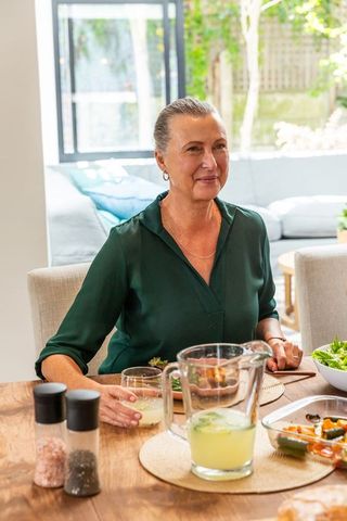 Senior Woman Enjoying Beverage and Meal by Sunny Window