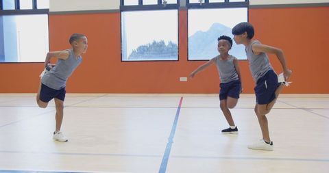 Diverse Boys Stretching in School Gymnasium for Physical Education